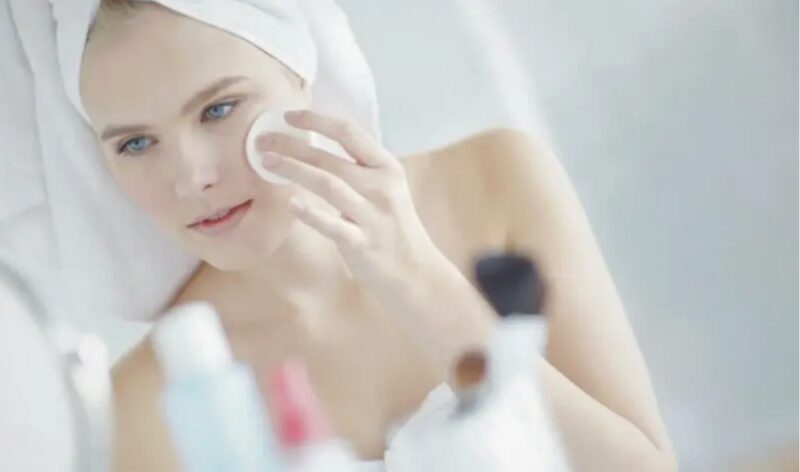コットンでスキンケアをしている女性の写真。肌に合わない化粧品による乾燥をイメージしています。